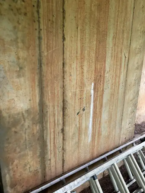 Foundation wall with red clay and mildew stains before washing
